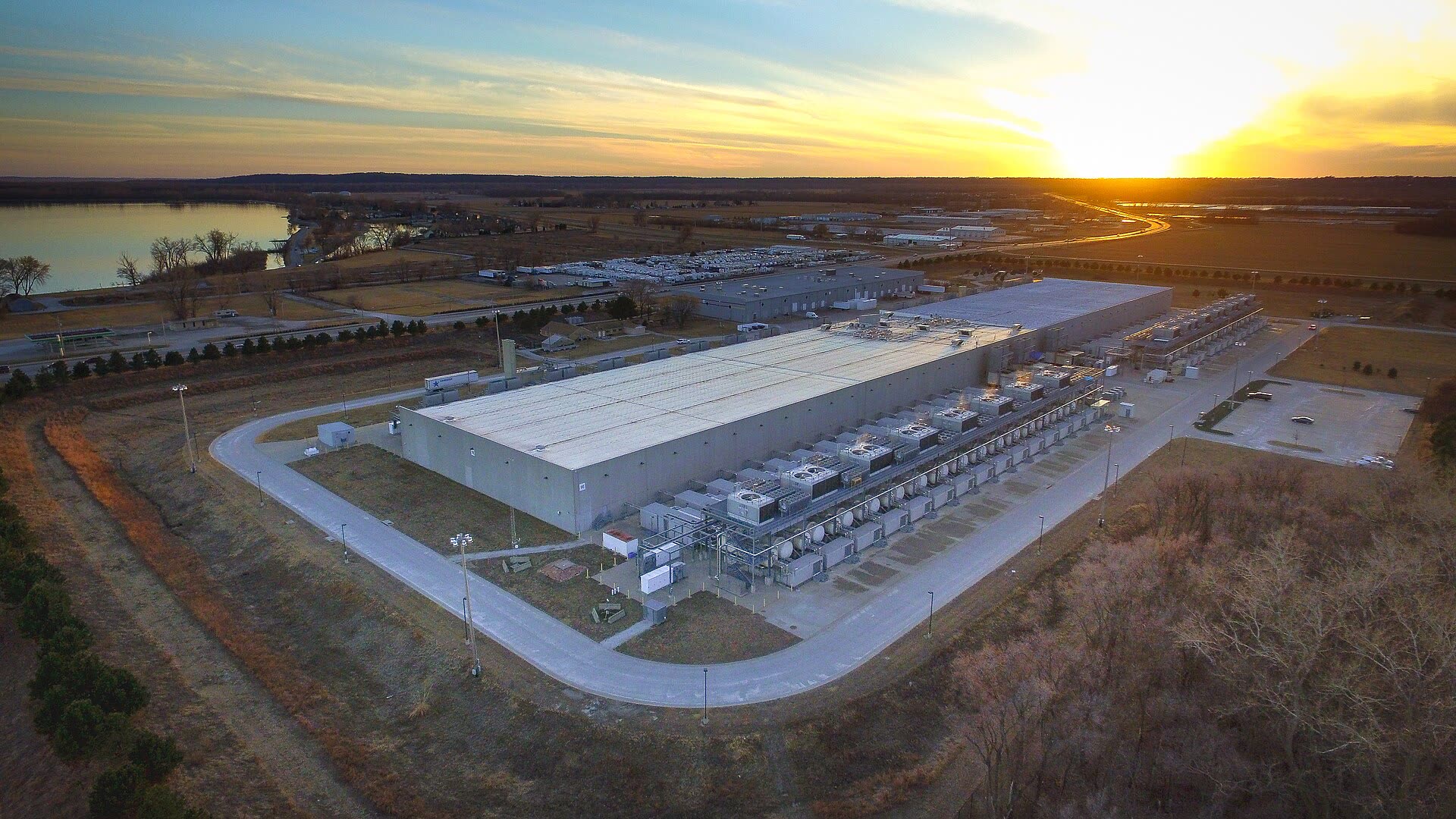 Aerial view of Google's huge data centre in Council Bluffs, Iowa, long white buildings in farmland at sunset